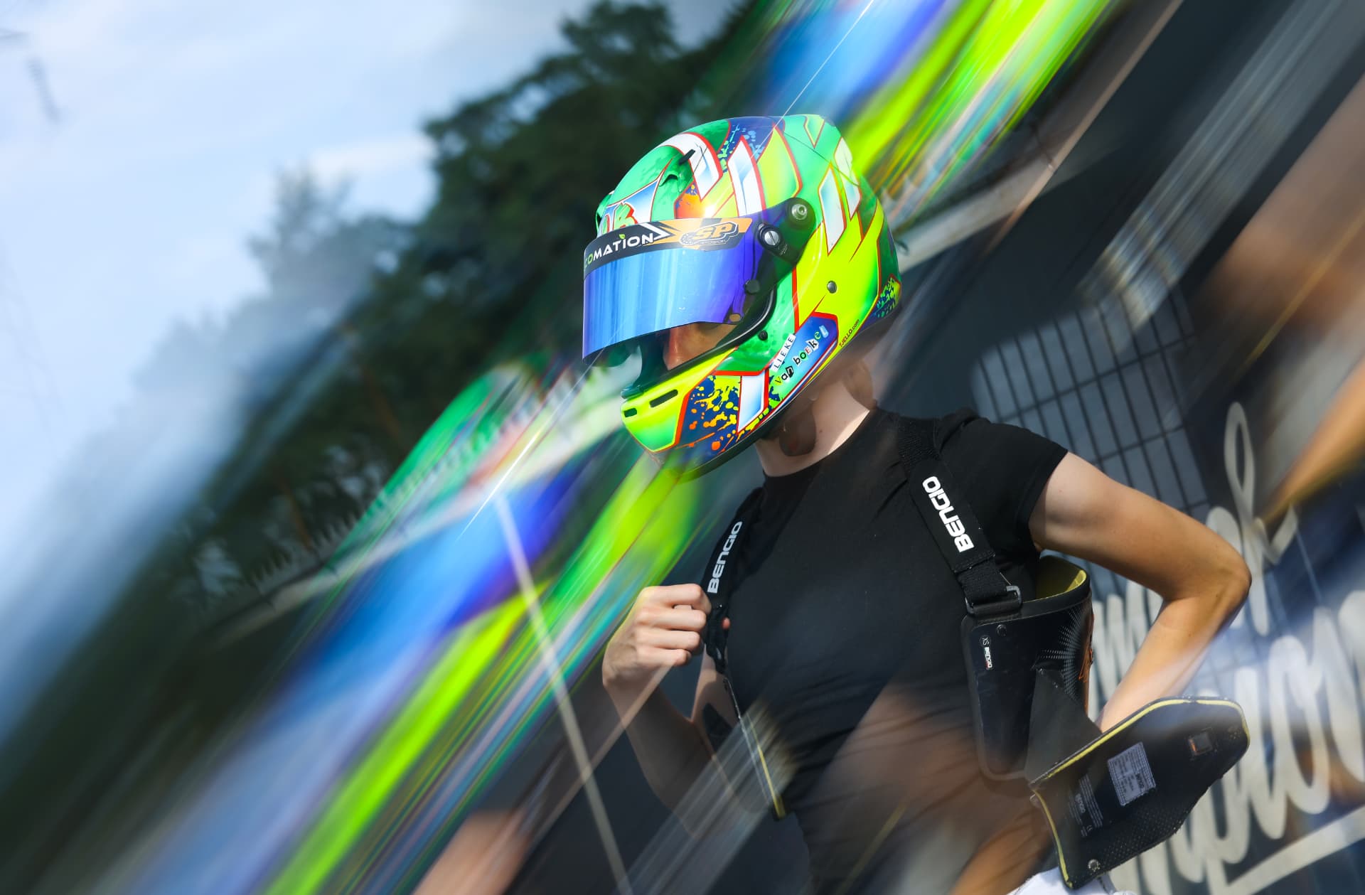 Lieke van Boekel in helmet and black t-shirt, carrying her kart seat